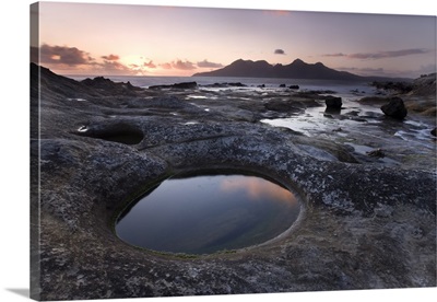 Isle of Rum at sunset from rock formation at Laig Bay, Isle of Eigg, Scotland