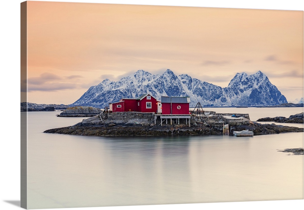 Isolated red fishermen's cabins on rocks in the cold sea at sunset, Svolvaer, Nordland county, Lofoten Islands, Norway, Sc...