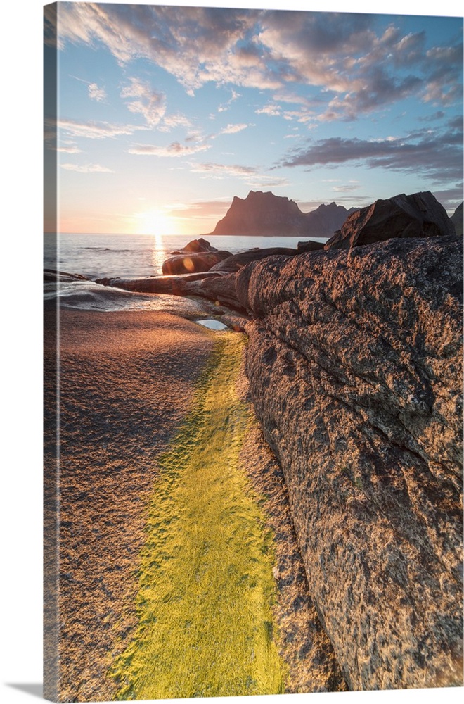 Lights of the midnight sun on the rocks surrounding the blue sea, Uttakleiv, Lofoten Islands, Northern Norway, Scandinavia...