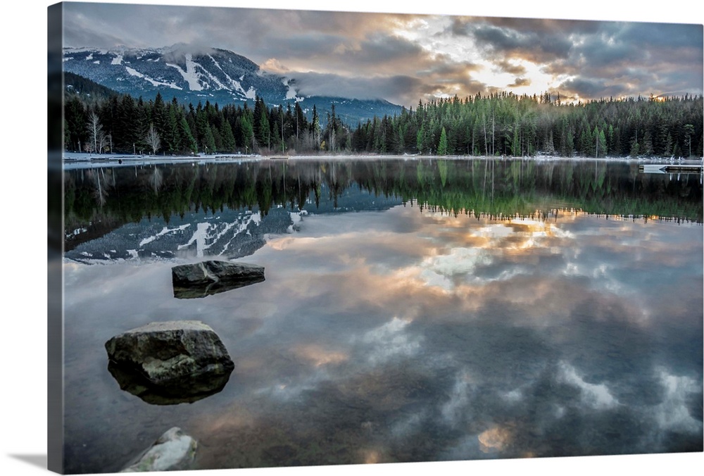 Lost Lake, so still it gives a perfect reflection of the sunset, ski hill and surrounding forest, Whistler, British Columb...