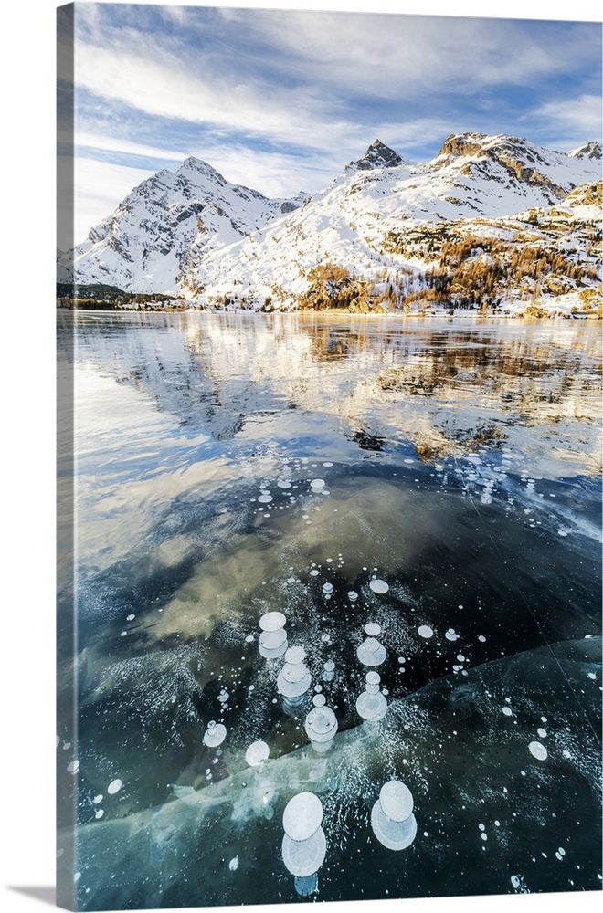 Methane bubbles in the icy surface of Silsersee with snowy peak, Lake Sils, Engadine Valley, Graubunden, Swiss Alps, Switz...