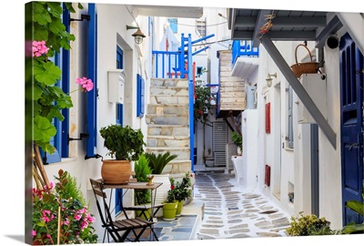 Narrow street, whitewashed buildings with blue paint work, flowers, Mykonos, Greece