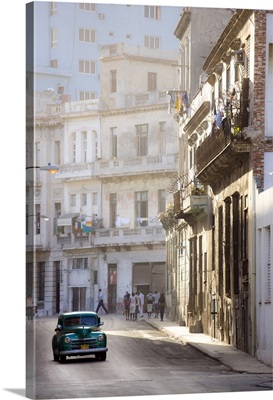 Old American car driving along quiet street in Havana Centro, Havana, Cuba, West Indies