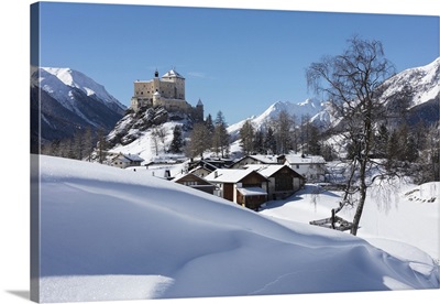 Old castle and alpine village of Tarasp surrounded by snowy peaks, Switzerland