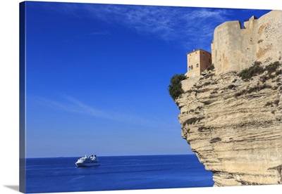 Old citadel atop cliffs with cruise ship anchored off shore, Bonifacio, Corsica, France