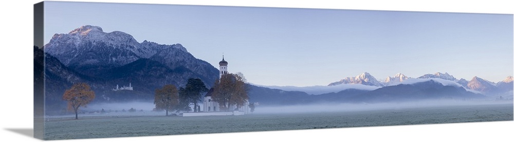 Panorama of St. Coloman Church surrounded by the autumn fog at sunrise, Schwangau, Bavaria, Germany