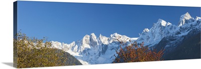 Panorama of the snowy peaks framed by colorful trees, Bregaglia Valley, Switzerland