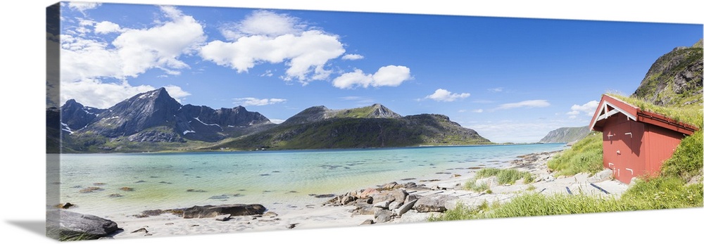 Panorama of the turquoise sea surrounded by peaks and typical house of fishermen, Strandveien, Lofoten Islands, Norway, Sc...