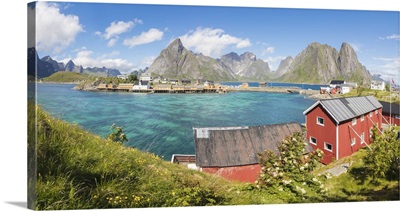 Panorama of turquoise sea and typical fishing village surrounded by rocky peaks, Norway