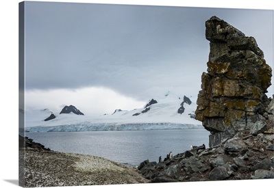 Penguins below dramatic rock formations, Half Moon Bay, Antarctica