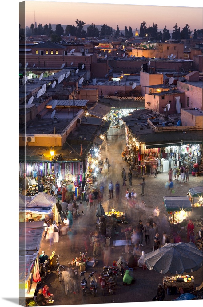 Crowds of locals and tourists walking among the shops and stalls in the Djemaa el Fna at sunset, Marrakech, Morocco, North...