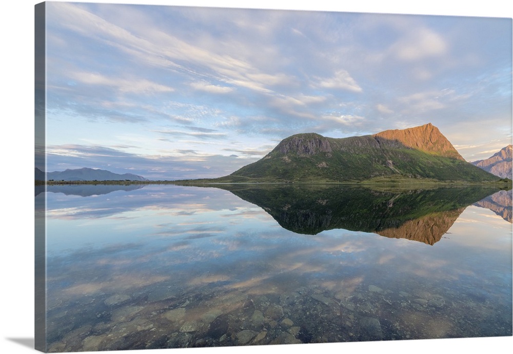 Pink clouds and peaks are reflected in the clear sea at night time, Vengeren, Vagspollen, Lofoten Islands, Norway, Scandin...