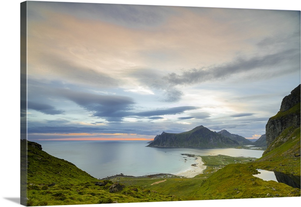 Pink clouds of the midnight sun reflected in the cold sea, Flakstad, Moskenesoya, Nordland county, Lofoten Islands, Norway...