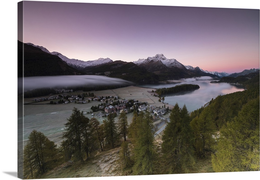 Pink sky at sunrise and mist on the lake and alpine village of Sils, Canton of Graubunden, Engadine, Switzerland, Europe