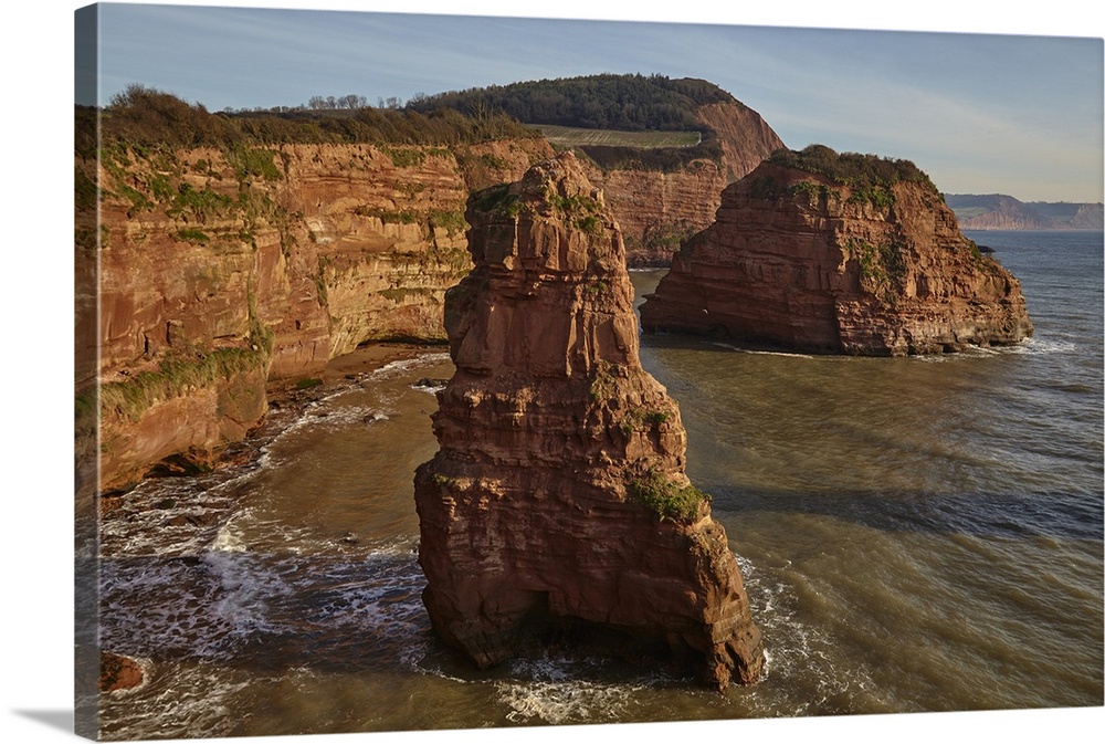 Red sandstone cliffs and rocks at Ladram Bay, in the Jurassic Coast UNESCO World Heritage Site, near Budleigh Salterton, E...