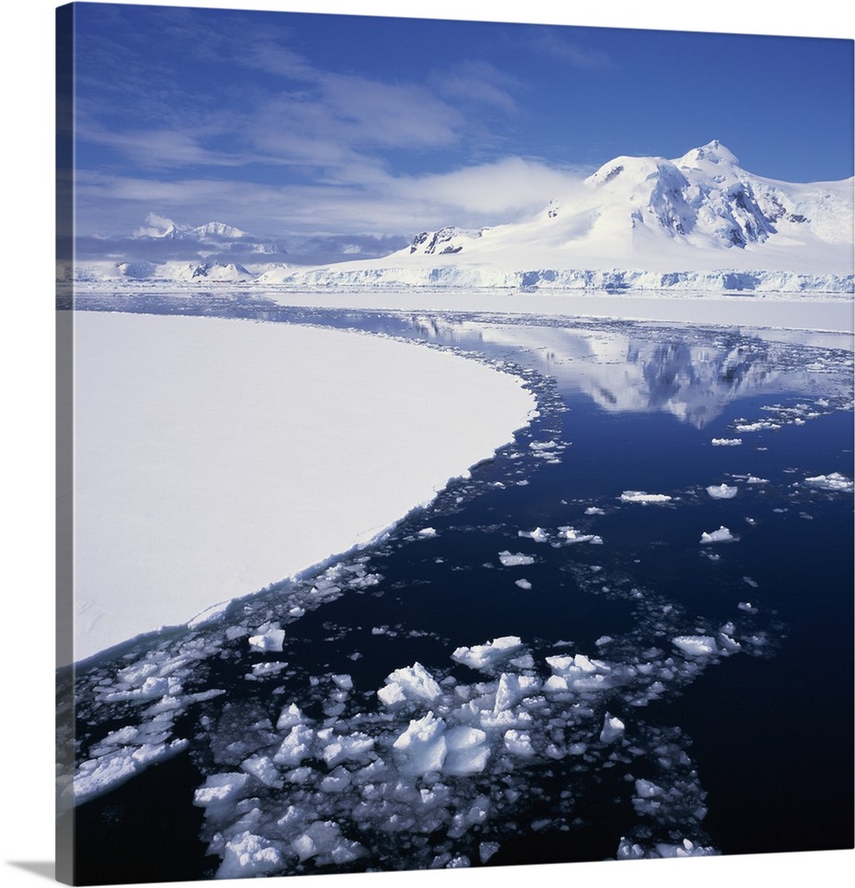 Reflections in icy sea of snow covered mountain, Antarctica