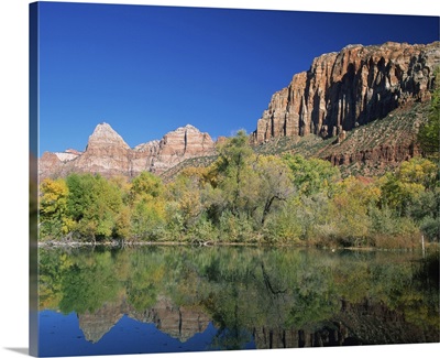 Reflections of trees in fall colours and cliffs of Zion, in a lake, Springdale, Utah