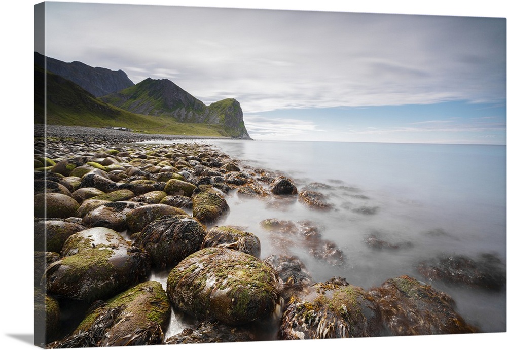 Rocks on the beach frame the calm clear sea, Unstad, Vestvagoy, Lofoten Islands, Norway, Scandinavia, Europe