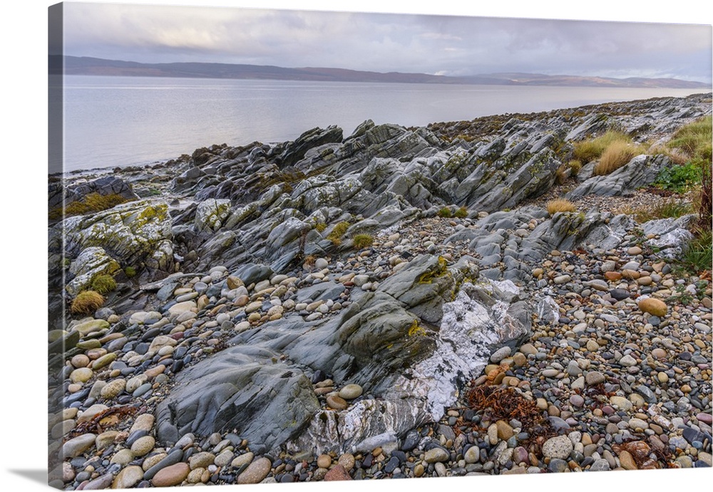 Rocky shore near Pirnmill looking out across the Kilbrannan Sound to Mull of Kintyre, Isle of Arran, North Ayrshire, Scotl...