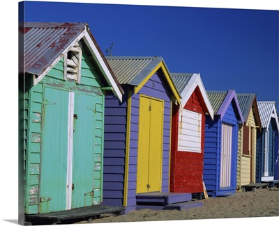 Row of beach huts painted in bright primary colours, Brighton Beach, Victoria, Australia