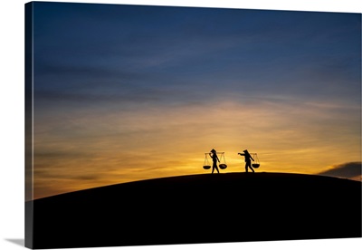 Silhouette Of Two People Carrying Baskets At Sunset, Vietnam
