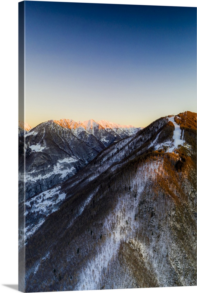 Aerial view by drone of ski slopes of Pian Delle Betulle and Alpe Paglio lit by sunset, Valsassina, Lecco province, Lombar...