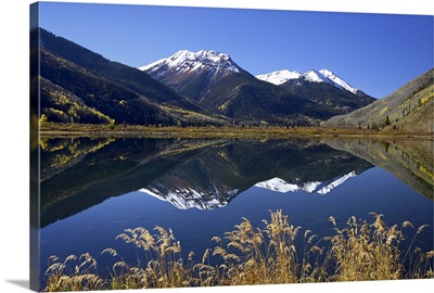 Snow-capped Red Mountain reflected in Crystal Lake with fall colors, Colorado