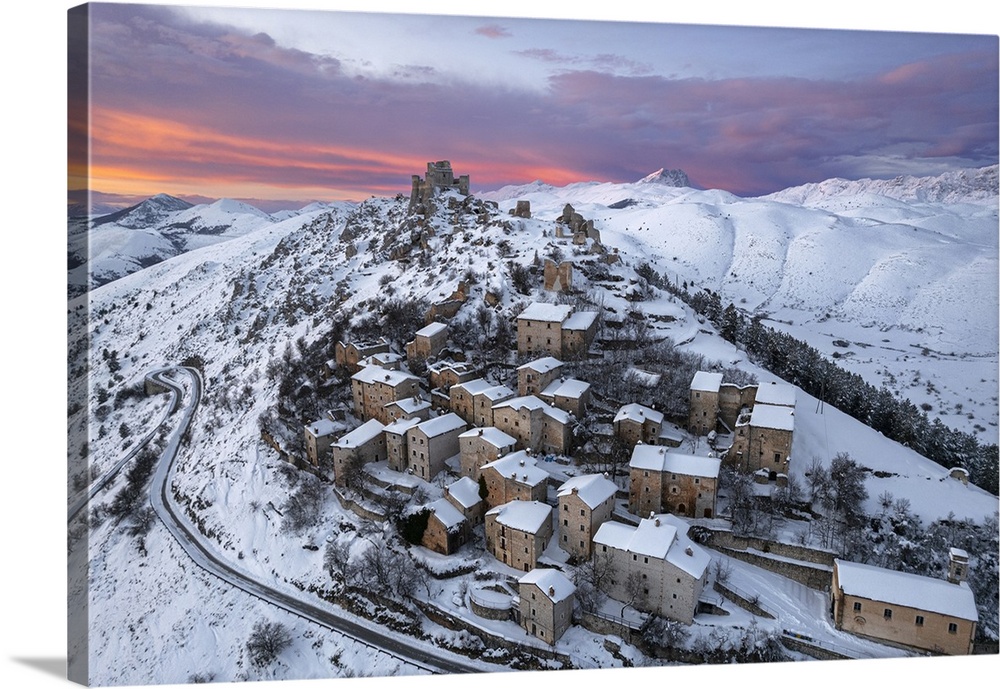 Aerial winter view of the snow covered medieval village of Rocca Calascio with the castle and pink clouds at dusk, Rocca C...