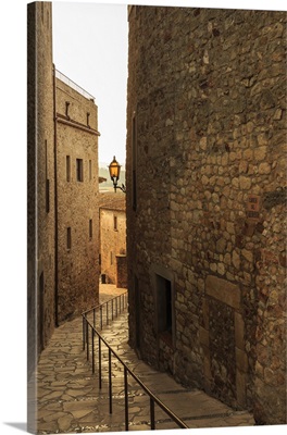 Steep and narrow winding street in the medieval hilltop walled village, Catalonia, Spain
