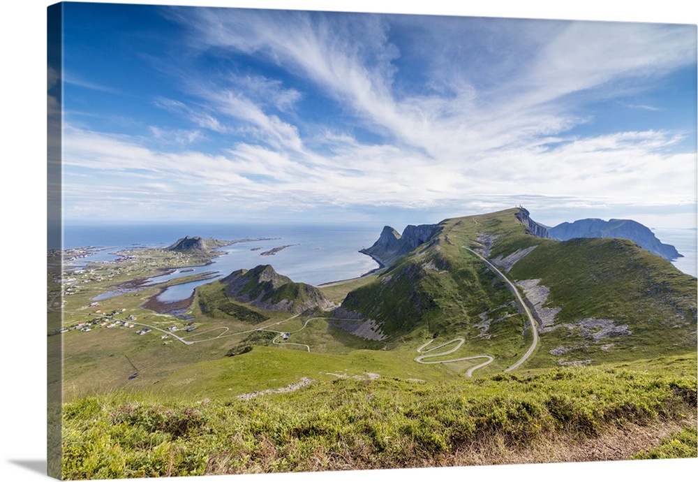 Steep road of curves in between green meadows and sea, Sorland, Vaeroy Island, county of Nordland, Lofoten Islands, Norway...