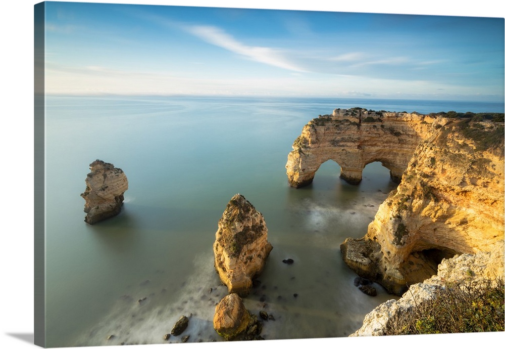 Sunrise on cliffs framed by turquoise water of the ocean, Praia da Marinha, Caramujeira, Lagoa Municipality, Algarve, Port...