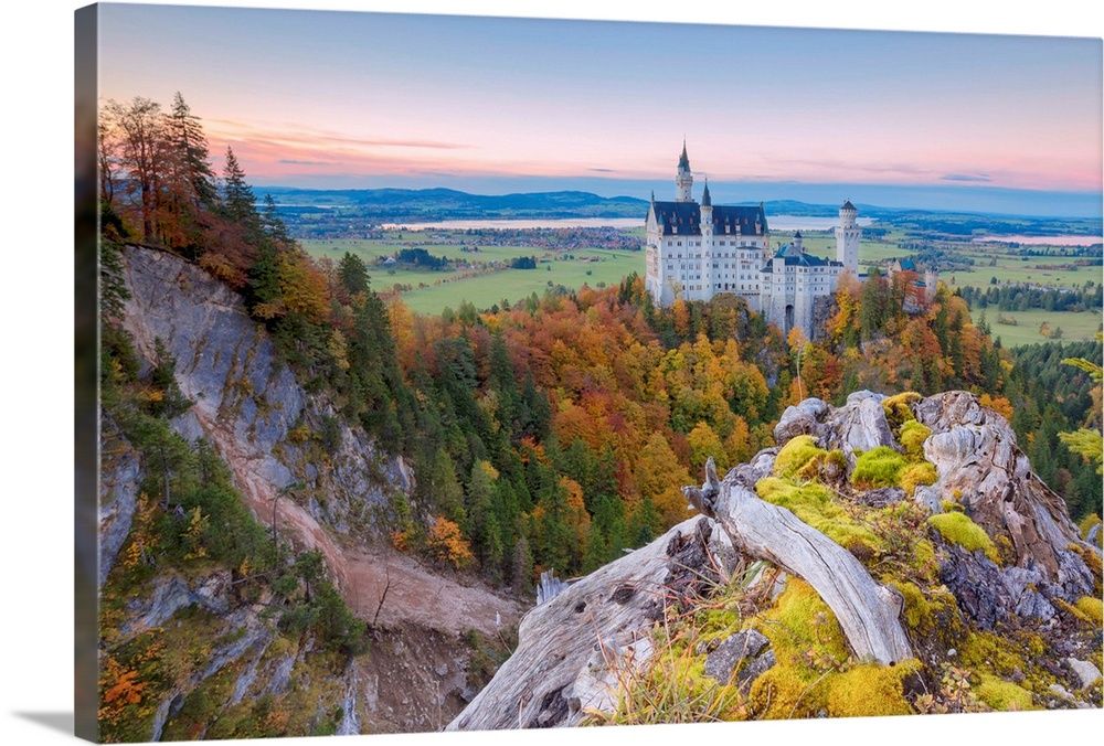 Sunset on Neuschwanstein Castle surrounded by colorful woods in autumn, Fussen, Bavaria, Germany