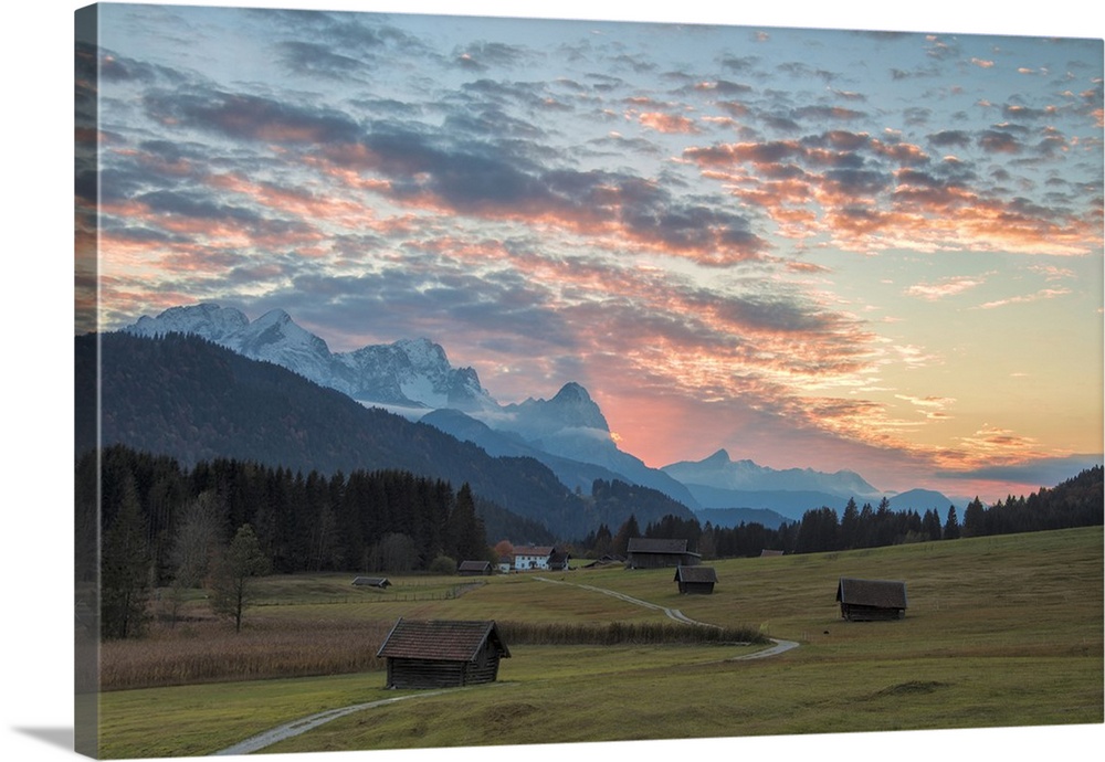 Sunset on wooden huts and meadows with the Alps in background, Geroldsee, Krun, Garmisch Partenkirchen, Upper Bavaria, Ger...