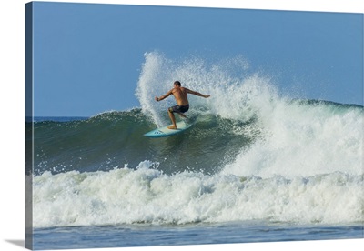 Surfer on shortboard riding wave at Playa Guiones surf beach, Costa Rica