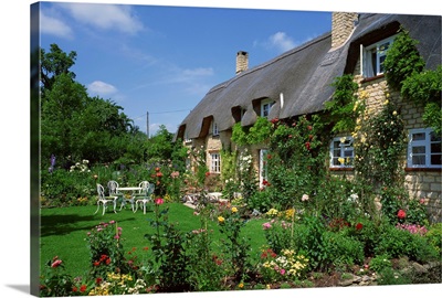 Thatched cottages with roses on the walls and gardens, Gloucestershire, England,