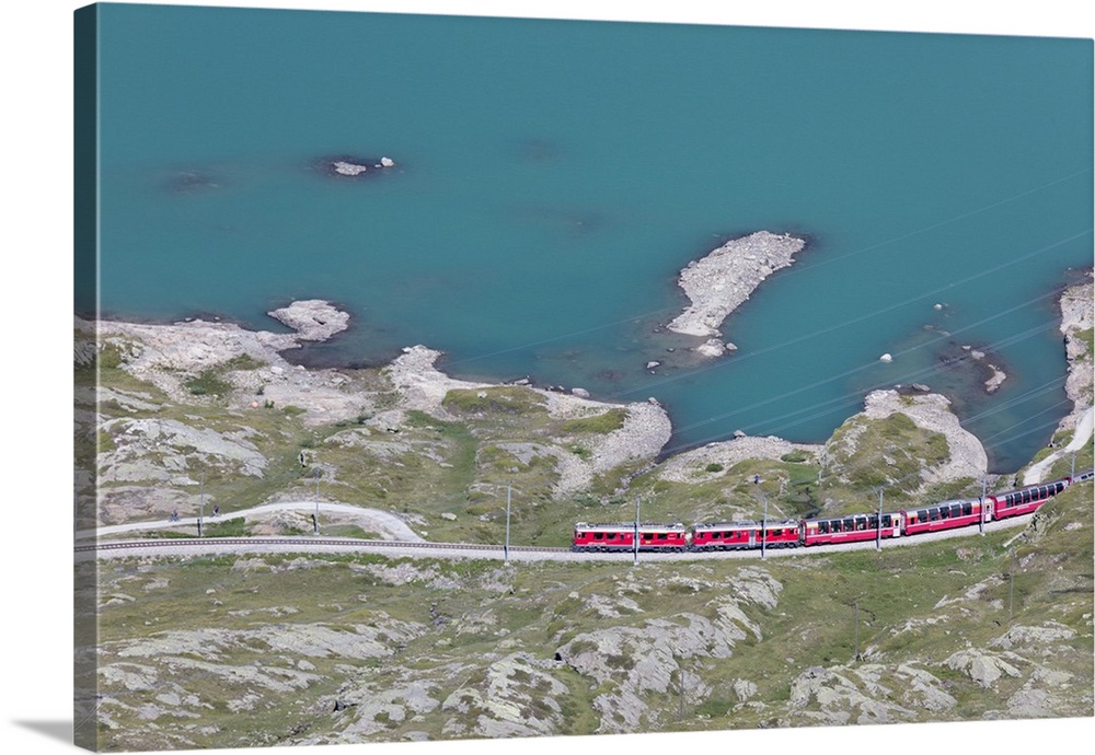 The Bernina Express train passes on the shores of Lago Bianco, Bernina Pass, Canton of Graubunden, Engadine, Switzerland, ...