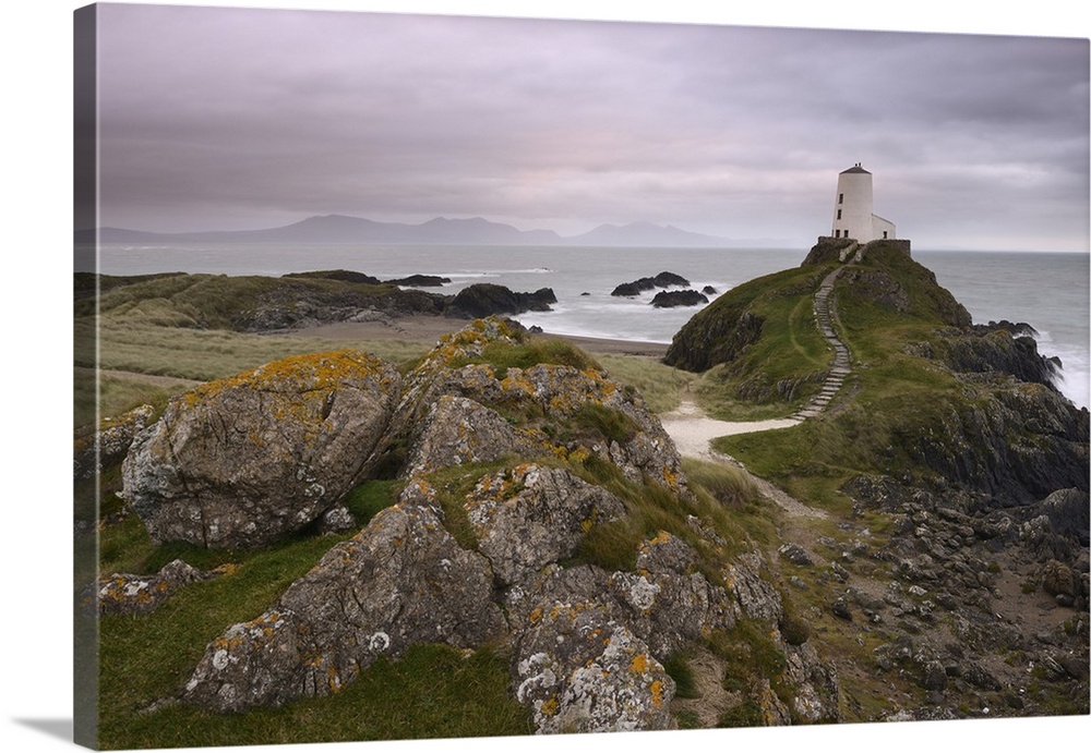 The lighthouse at the edge of Llanddwyn Islan, under a pink cloudy sky, Anglesey, Wales