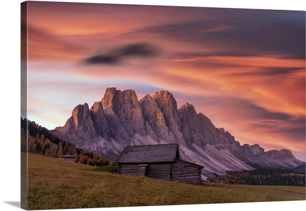 Sunrise over the Odle peaks and traditional hut in Gampen Alm in autumn, Funes Valley, Dolomites, Bolzano, South Tyrol, It...