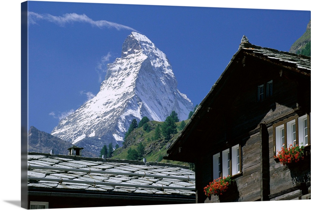 The peak of the Matterhorn mountain towering above chalet rooftops, Zermatt, Valais, Swiss Alps, Switzerland