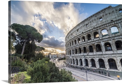 The pink sky at sunrise frames the ancient Colosseum, Rome, Lazio, Italy