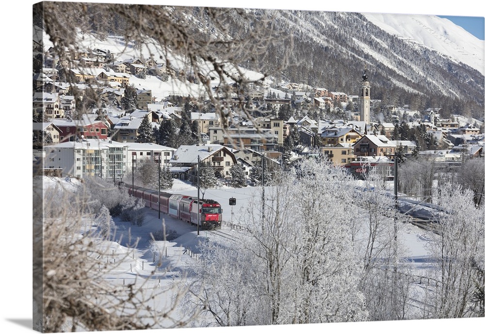 The red train runs across the snowy landscape around Samedan, Maloja, Canton of Graubunden, Engadine, Switzerland, Europe
