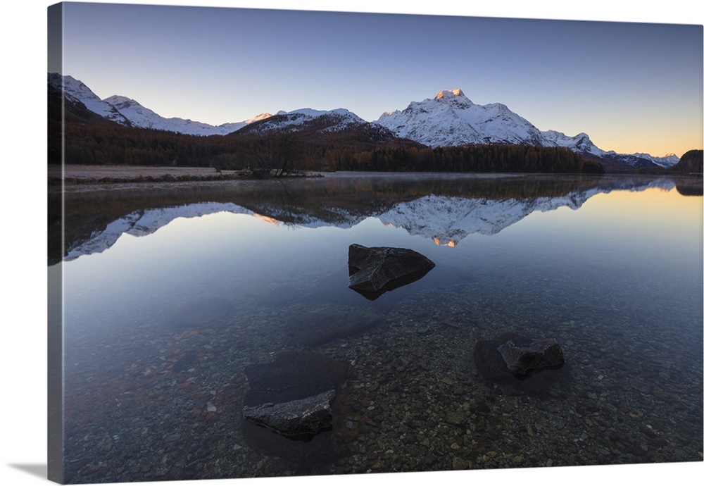 The snowy peaks are reflected in Lake Champfer at sunrise, St. Moritz, Canton of Graubunden, Engadine, Switzerland