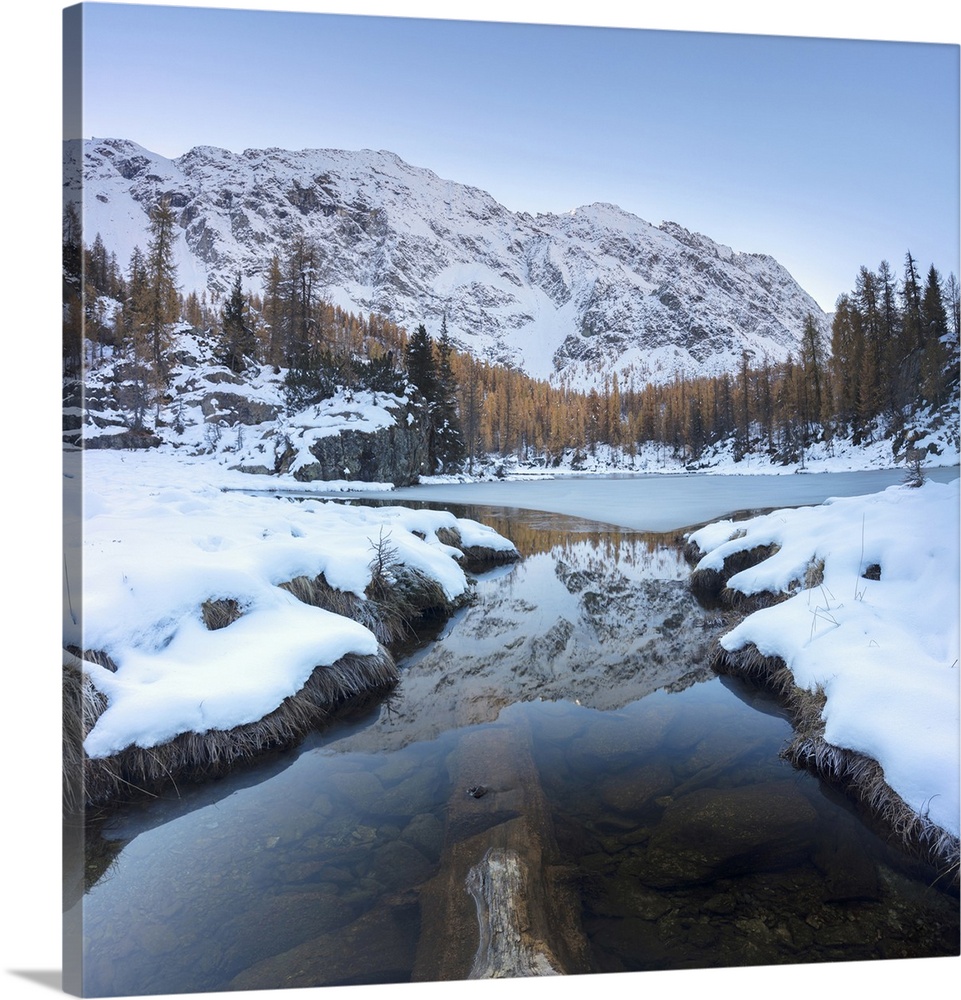 The snowy peaks reflected in the frozen Lake Mufule, Malenco Valley, Province of Sondrio, Valtellina, Lombardy, Italy