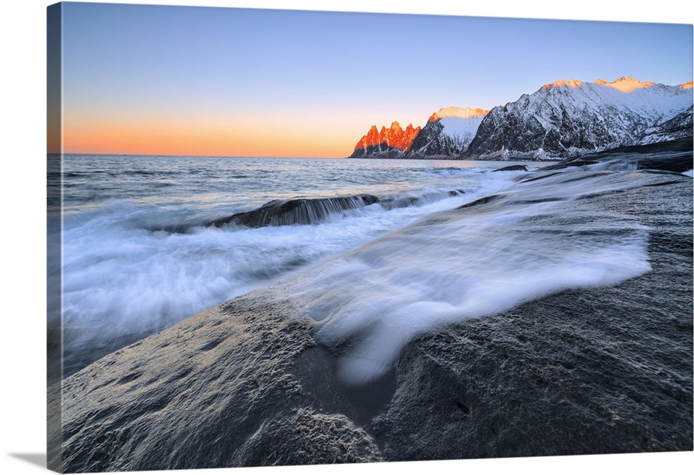 The waves of the icy sea crashing on the rocky cliffs at dawn Tungeneset, Senja, Troms county, Arctic, Norway, Scandinavia...