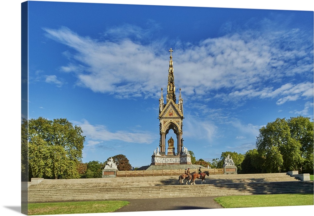 Three heavy horses are ridden past The Albert Memorial, Kensington Gardens, Hyde Park, London, England
