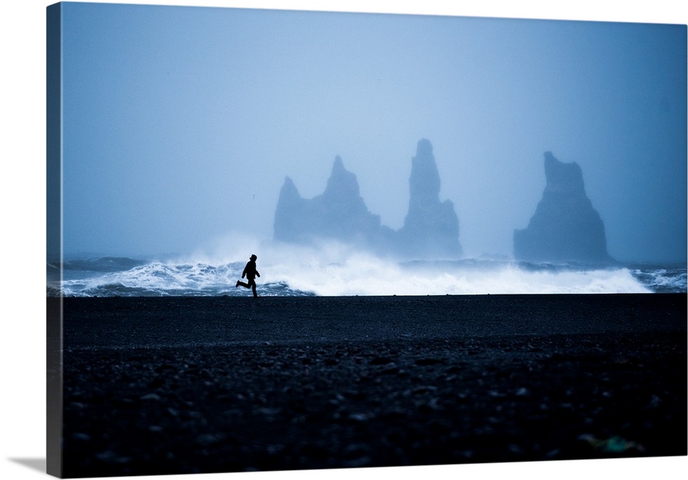 Tourist running on Black Sand Beach, Iceland