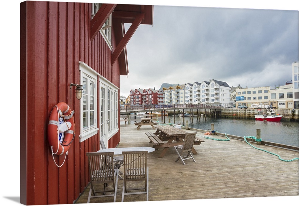 Clouds frame the typical wooden houses of the fishing village surrounded by sea, Svolvaer, Vagan, Lofoten Islands, Norway,...