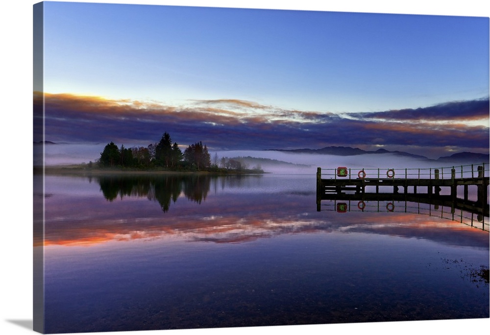 A tranquil view across the calm waters of Loch Shiel as dawn breaks on a misty winter morning. Ardnamurchan, Scottish High...