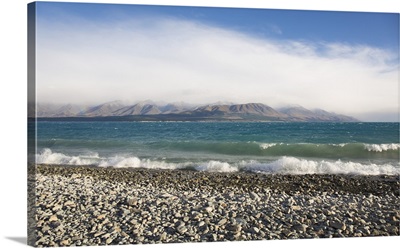 View from rocky shoreline across the stormy waters of Lake Pukaki, New Zealand