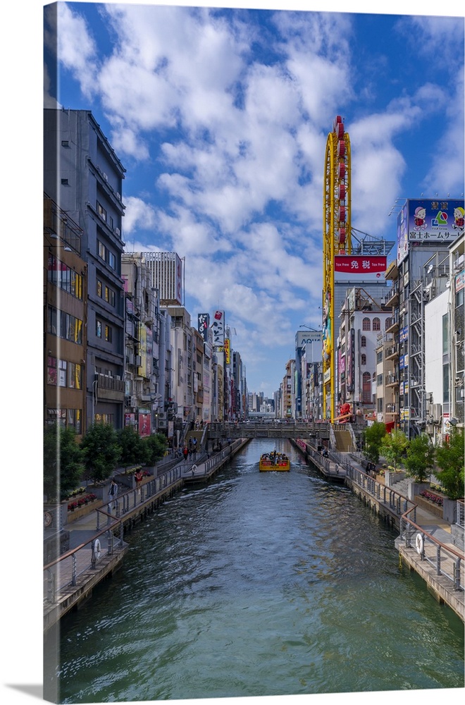 View of restaurants and tour boat in Dotonbori, vibrant entertainment district near the river, Osaka, Honshu, Japan
